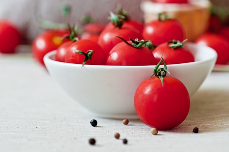 cherry tomatoes with white cup and pepper grainsの写真素材