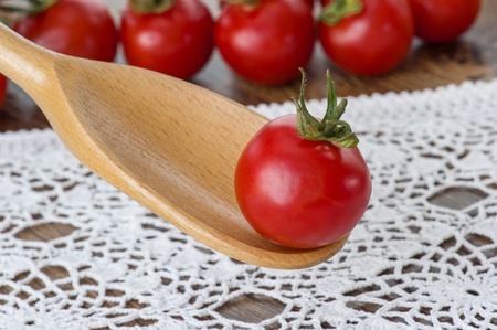cherry tomato over a wooden spoon の写真素材