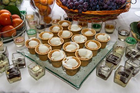 ice cream and mixed fruits with chocolates on white table for a dinner partyの写真素材