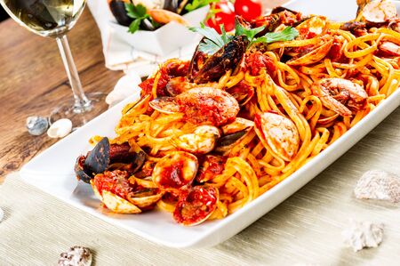 Spaghetti with mussels and tomato sauce on wooden tableの写真素材