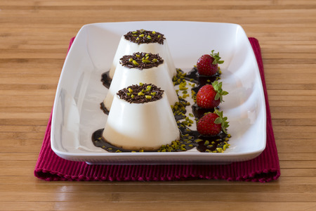 Italian dessert called "panna cotta" with strawberries on wooden tableの写真素材