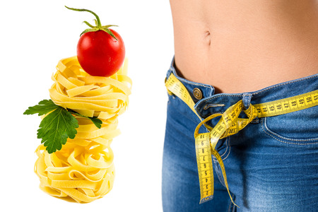 Young woman wearing jeans after diet and food background with food backgroundの写真素材