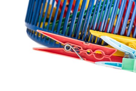mixed clothespins with plastic basket isolated on white backgroundの写真素材