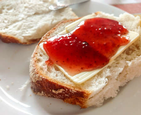 Bread with butter and a strawberry jam, morning breakfastの写真素材