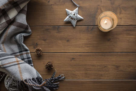 Christmas or winter background with a plaid, fir cones, Christmas tree decoration and candle, top viewの写真素材