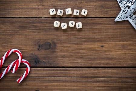 Christmas background with candy canes and wooden blocks (letters) spelling out Merry Xmas, top view