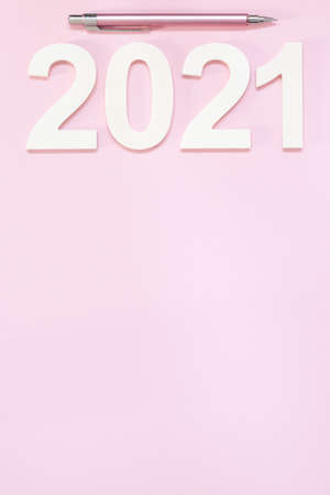 New year 2021 pink background with a pink pencil. Planning concept for a calendar or agenda. Minimalistic design. Copy space.の写真素材
