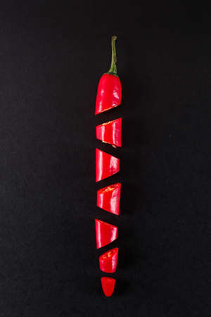 Fresh red pepper cut into slices on black backgroundの写真素材