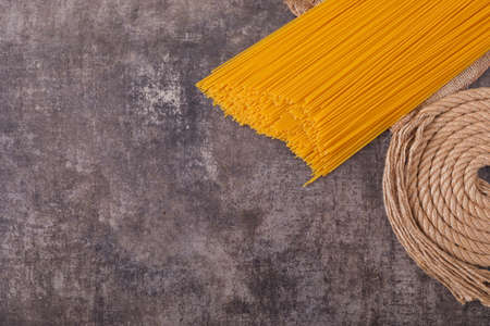 Raw spaghetti with rope, top view on gray background top viewの写真素材