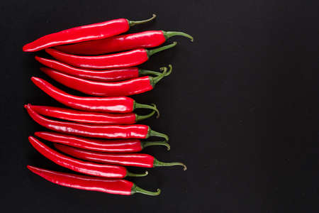Chili peppers top view with copy space on black background