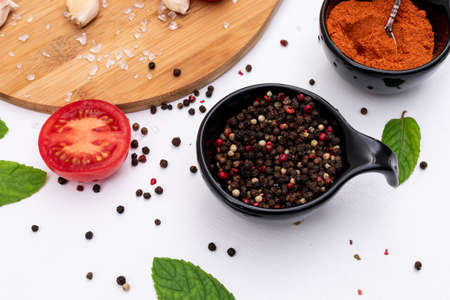Spices black pepper and red powder pepper on white background