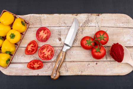 Tomatoes top view concept on cutting board with knife and pepperの写真素材