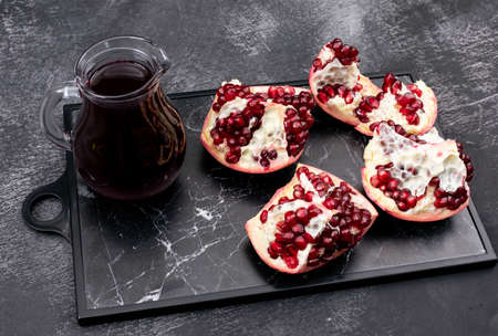 Fresh pomegranate juice decanter on dark tray