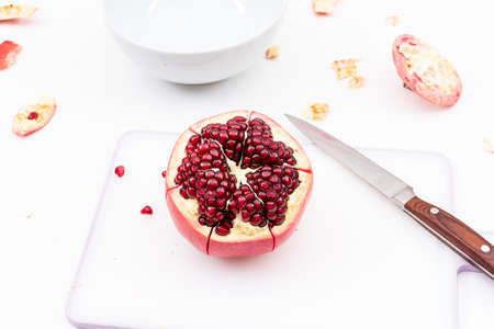 Fresh pomegranate on cutting board with knifeの写真素材