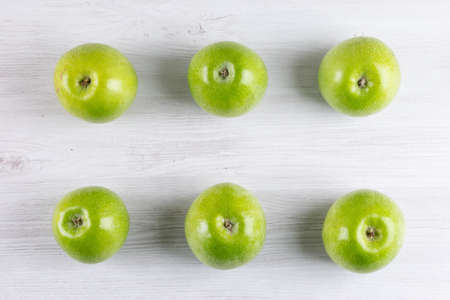 Top view green apples on white wooden background horizontalの写真素材