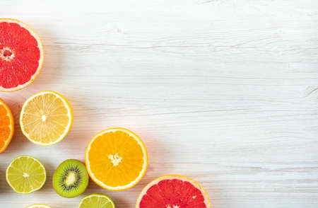 Citrus fruit slices top view with copy space on wood backgroundの写真素材