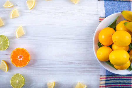 Lemons and bananas in white plate on the clothの写真素材