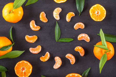 Slice of mandarin arranged as clock on black backgroundの写真素材