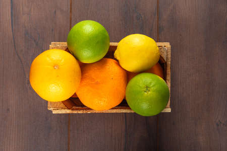 Top view citrus fruits in wooden box on wooden tableの写真素材
