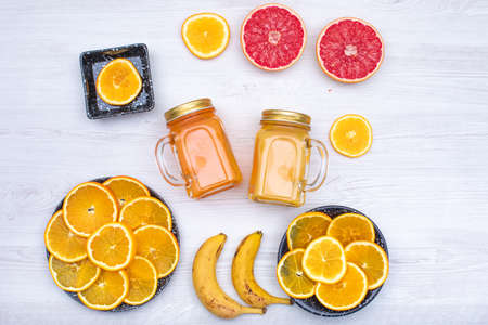 Top view citrus fruit juice oranges, bananas on wooden backgroundの写真素材