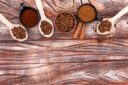 Top view coffee beans in spoons and plates on wooden backgroundの写真素材