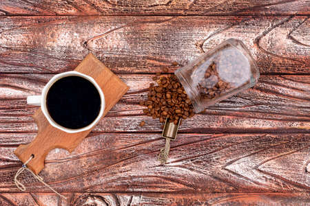Black coffee on wood board with jar of coffee beansの写真素材