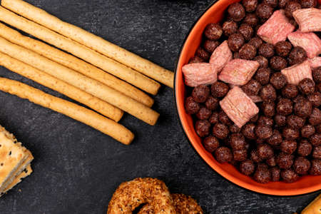 Top view cereal balls in plate and bread sticks on dark backgroundの写真素材