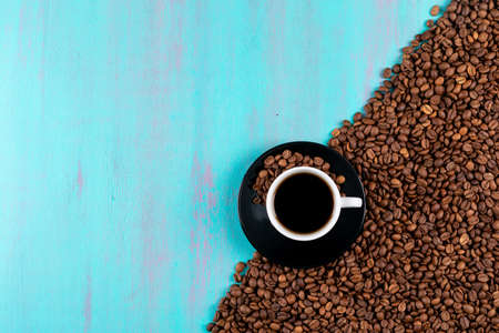Top view coffee cup with coffee beans on blue table