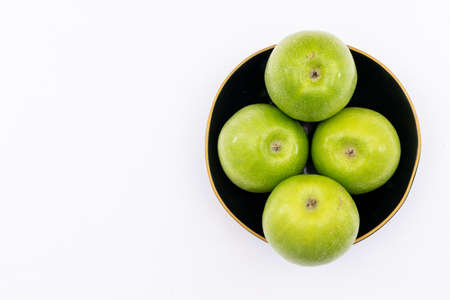 Top view green apple in black bowl on white backgroundの写真素材