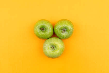 Top view green apple on yellow backgroundの写真素材