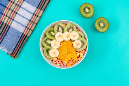 Top view of corn rings with fruits on blue background horizontalの写真素材