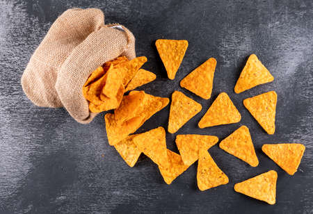 Top view chips in linen bag on black stone background horizontal
