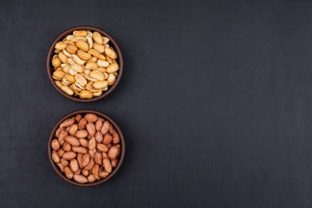 Top view peanuts in bowl on dark background with copy spaceの写真素材