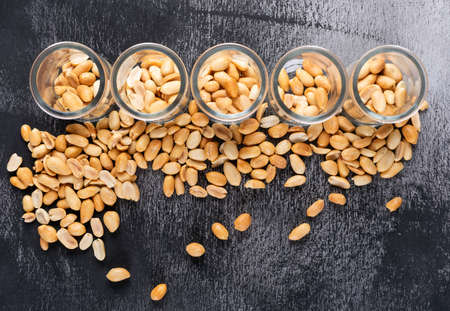 Top view peanuts in jars on stone background horizontal