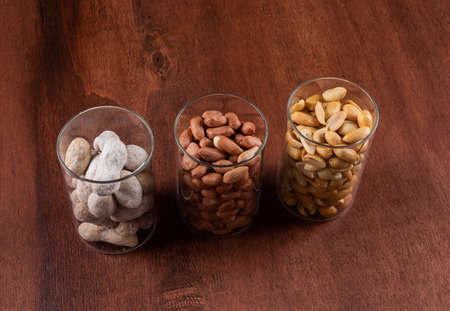 High angle view peanuts in glasses on brown background