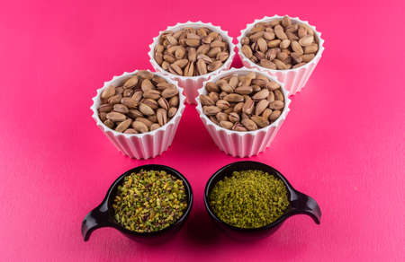 High angle view pistachios in bowls on pink background horizontalの写真素材