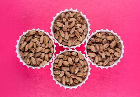 Top view pistachios in a bowl on pink background horizontal の写真素材