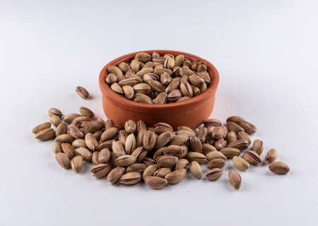 Top view pistachios in a bowl on white background horizontal の写真素材