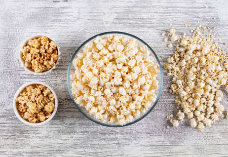 Top view of popcorn in bowls on white wooden background horizontal