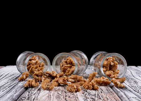 Side view walnuts in jars on wooden table horizontal の写真素材