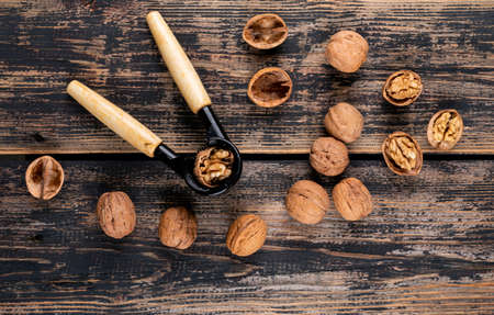 Top view walnuts with nutcracker on wooden background horizontalの写真素材