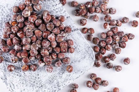 Shelled hazelnuts on a white stone background. flat lay. の写真素材