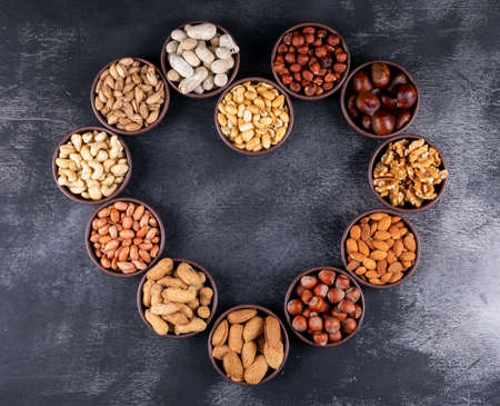 Assorted nuts and dried fruits in a heart shaped mini different bowls with pecan, pistachios,...