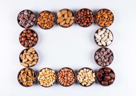 Set of pecan, pistachios, almond, peanut, cashew, pine nuts and different nuts in a black blows on a...