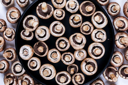 Mushrooms in a pan flat lay on a light wooden background