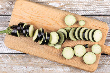 Chopped eggplant in a cutting board on a wooden background. flat lay.の写真素材