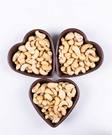 Top view cashews in heart shaped blow on white background. verticalの写真素材