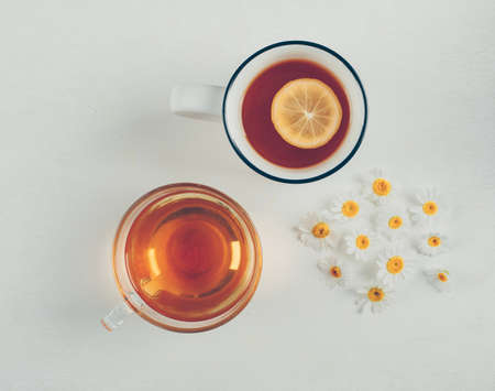 Teas and flowers in cups on a white background. top view.の写真素材