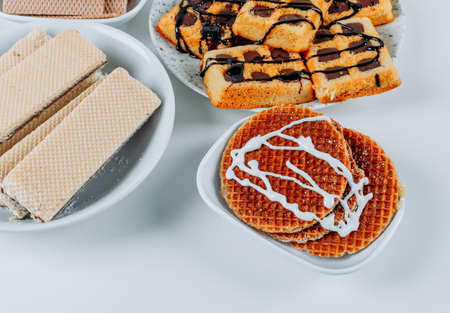 High angle view waffles in bowls with cookies on white background. horizontal
