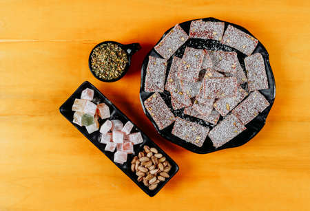 Top view turkish delight lokums in plate with pistachio on yellow wooden background. horizontalの写真素材
